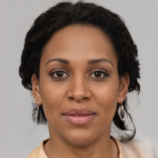 Joyful black young-adult female with medium  brown hair and brown eyes