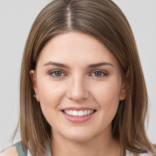 Joyful white young-adult female with medium  brown hair and grey eyes