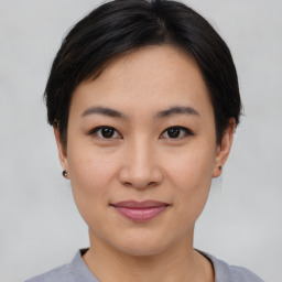 Joyful asian young-adult female with short  brown hair and brown eyes