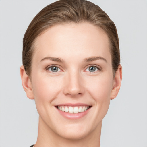 Joyful white young-adult female with short  brown hair and grey eyes