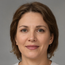 Joyful white adult female with medium  brown hair and brown eyes