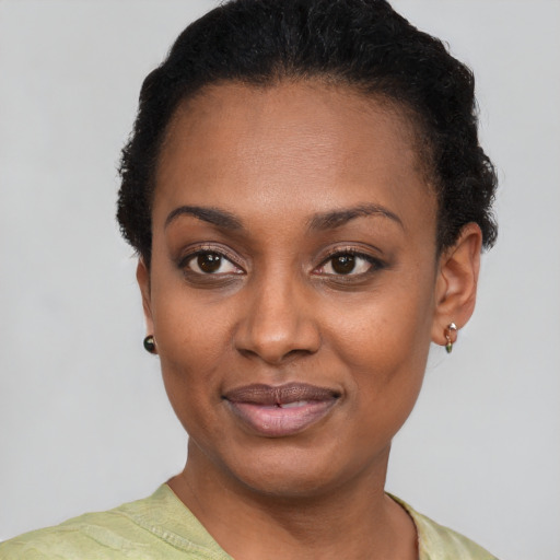 Joyful black young-adult female with short  black hair and brown eyes