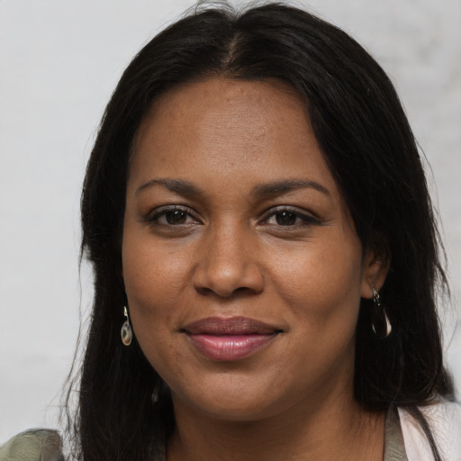 Joyful black young-adult female with long  brown hair and brown eyes