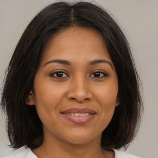 Joyful latino young-adult female with medium  brown hair and brown eyes