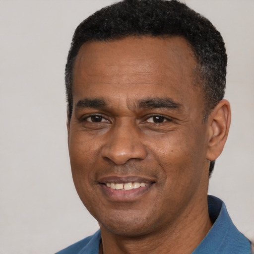 Joyful black adult male with short  black hair and brown eyes