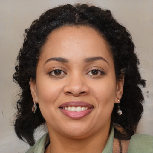 Joyful latino adult female with medium  brown hair and brown eyes