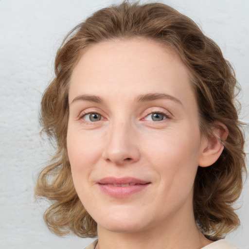 Joyful white young-adult female with medium  brown hair and green eyes