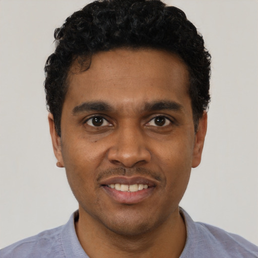 Joyful black young-adult male with short  black hair and brown eyes