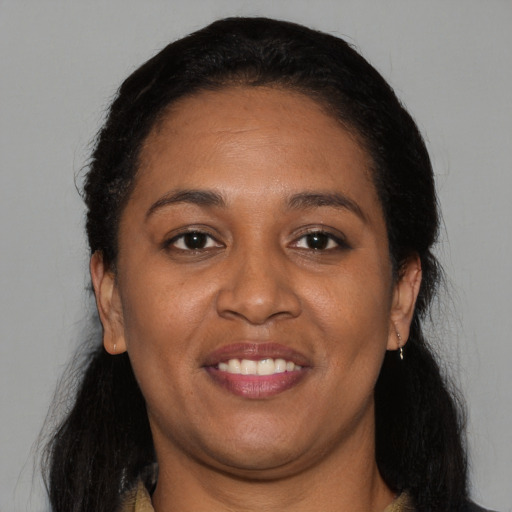 Joyful black adult female with long  black hair and brown eyes