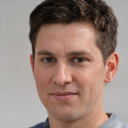 Joyful white adult male with short  brown hair and grey eyes