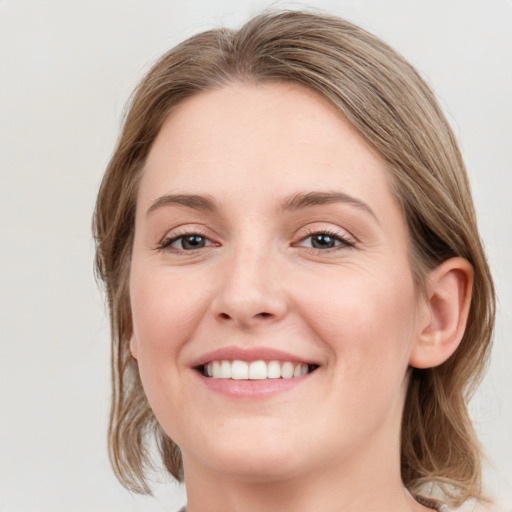 Joyful white young-adult female with medium  brown hair and grey eyes