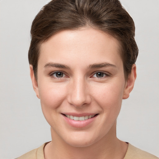 Joyful white young-adult female with short  brown hair and grey eyes