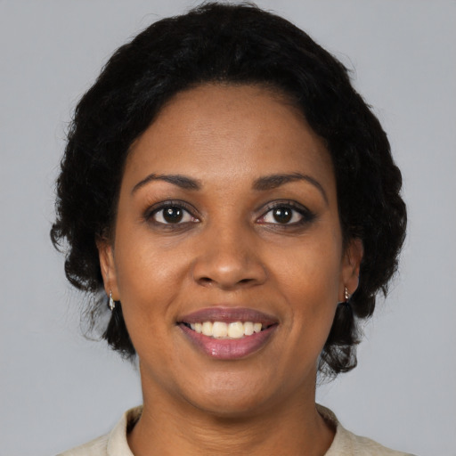 Joyful black young-adult female with medium  black hair and brown eyes