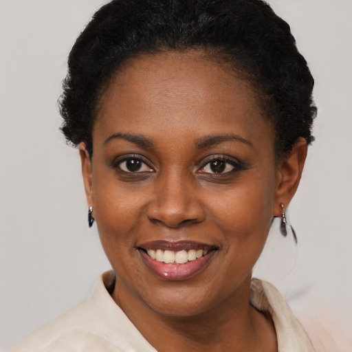 Joyful black young-adult female with short  black hair and brown eyes