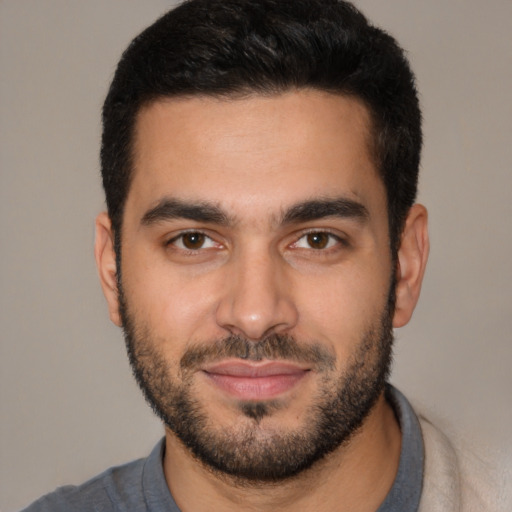 Joyful latino young-adult male with short  black hair and brown eyes