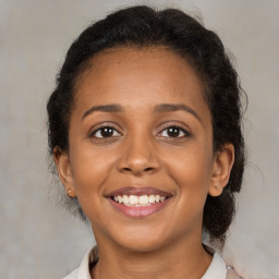 Joyful black young-adult female with medium  brown hair and brown eyes