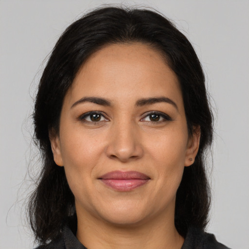 Joyful latino adult female with long  brown hair and brown eyes
