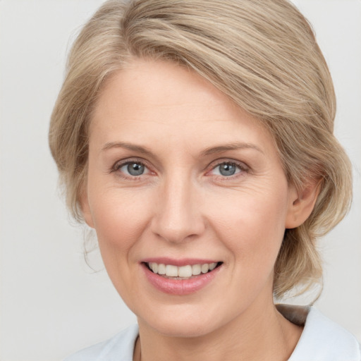 Joyful white adult female with medium  brown hair and blue eyes