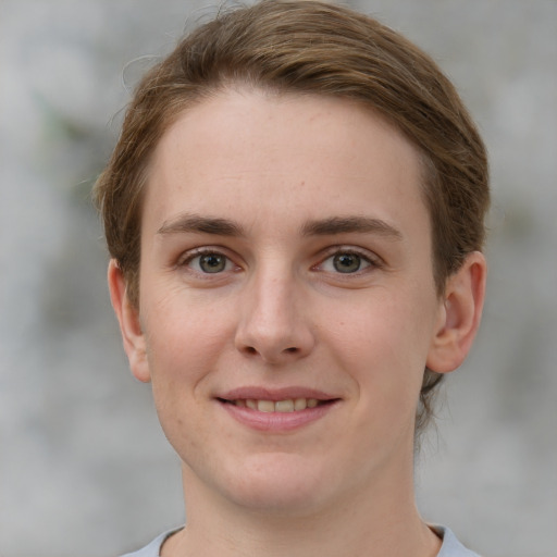 Joyful white young-adult female with short  brown hair and grey eyes