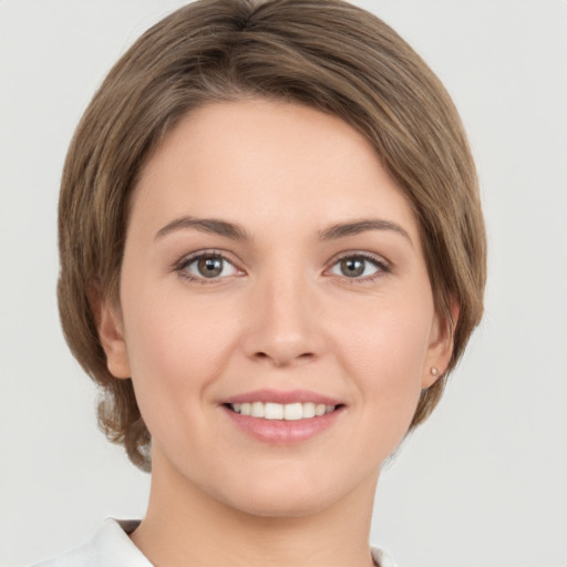 Joyful white young-adult female with medium  brown hair and grey eyes