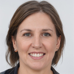 Joyful white adult female with medium  brown hair and grey eyes