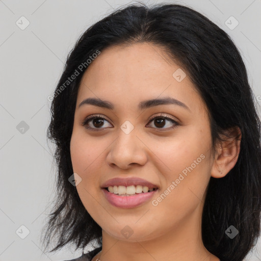 Joyful latino young-adult female with long  brown hair and brown eyes