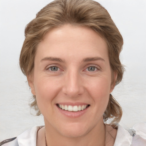 Joyful white young-adult female with medium  brown hair and grey eyes