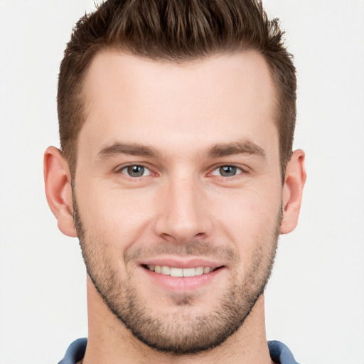 Joyful white young-adult male with short  brown hair and grey eyes