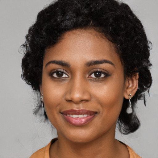 Joyful black young-adult female with long  black hair and brown eyes