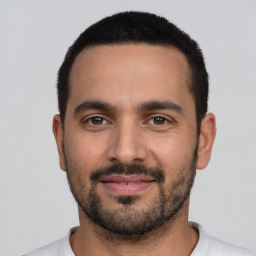 Joyful white young-adult male with short  black hair and brown eyes