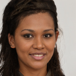 Joyful latino young-adult female with long  brown hair and brown eyes