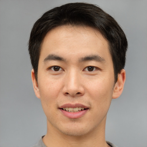 Joyful asian young-adult male with short  brown hair and brown eyes