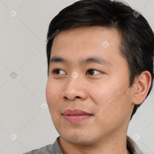 Joyful asian young-adult male with short  black hair and brown eyes