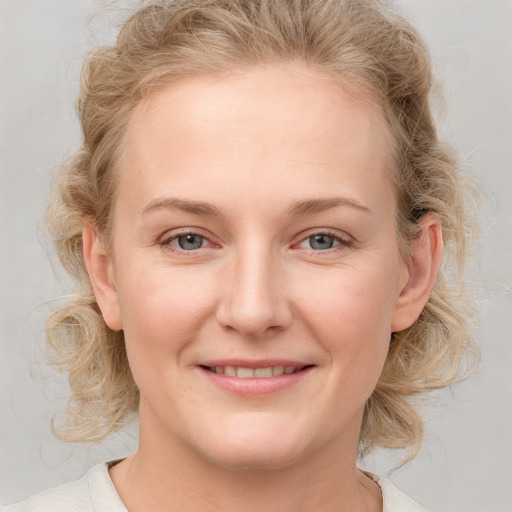 Joyful white young-adult female with medium  brown hair and blue eyes