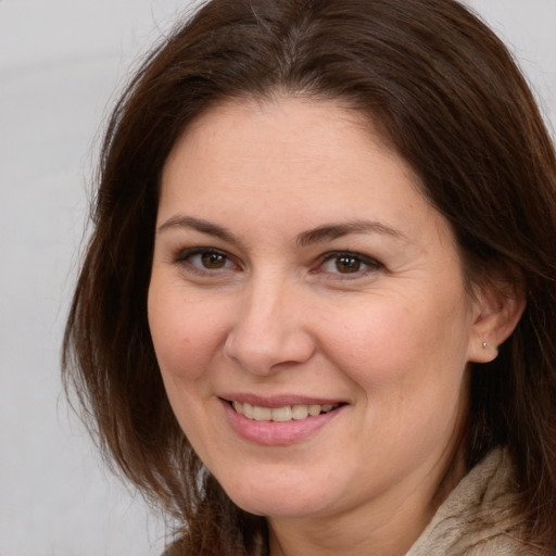 Joyful white adult female with long  brown hair and brown eyes