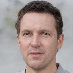 Joyful white adult male with short  brown hair and grey eyes