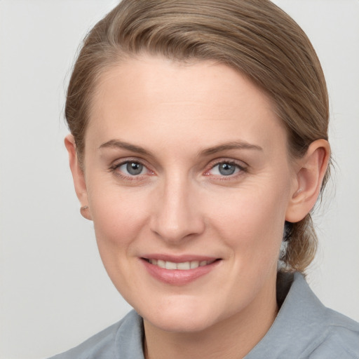 Joyful white young-adult female with medium  brown hair and blue eyes