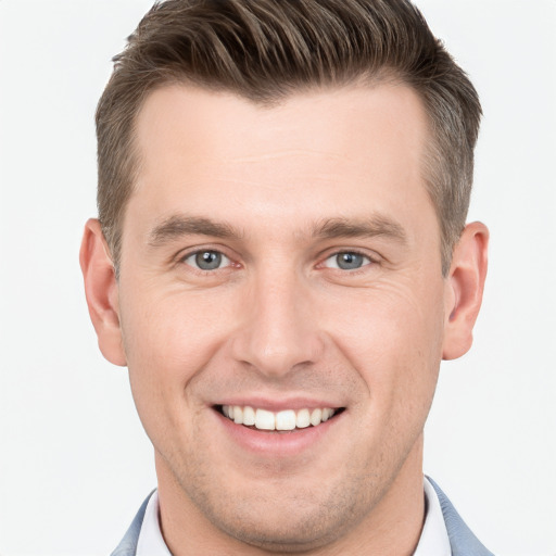 Joyful white young-adult male with short  brown hair and grey eyes