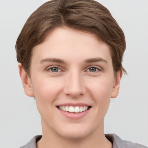 Joyful white young-adult female with short  brown hair and grey eyes