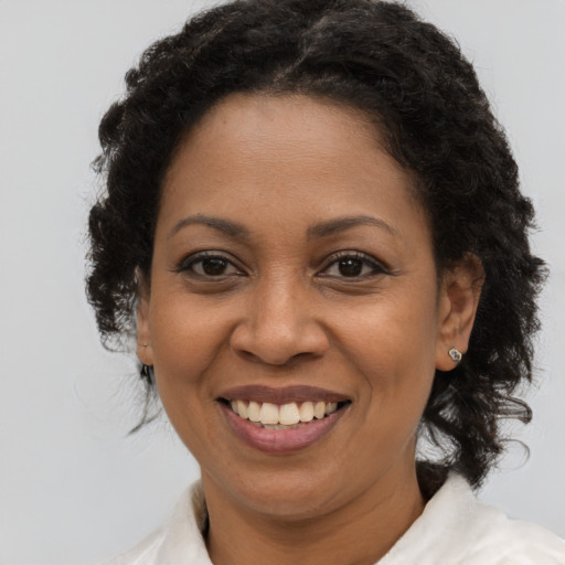 Joyful black adult female with medium  brown hair and brown eyes