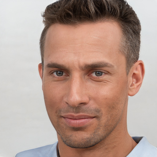 Joyful white adult male with short  brown hair and brown eyes