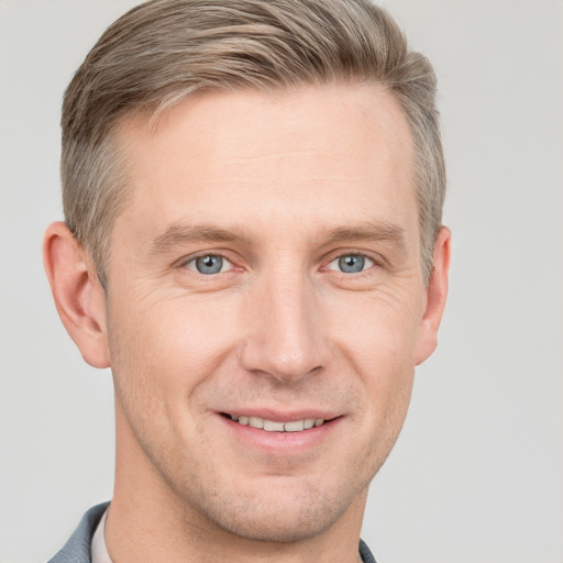 Joyful white adult male with short  brown hair and blue eyes