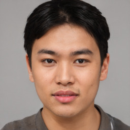 Joyful asian young-adult male with short  black hair and brown eyes