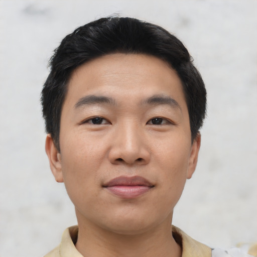 Joyful asian young-adult male with short  black hair and brown eyes