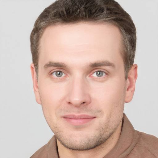 Joyful white young-adult male with short  brown hair and grey eyes