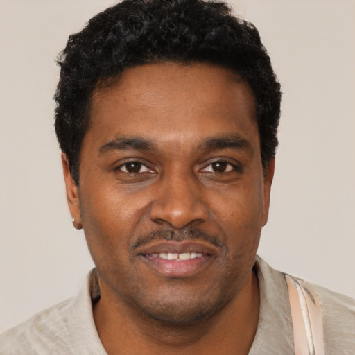 Joyful black young-adult male with short  black hair and brown eyes
