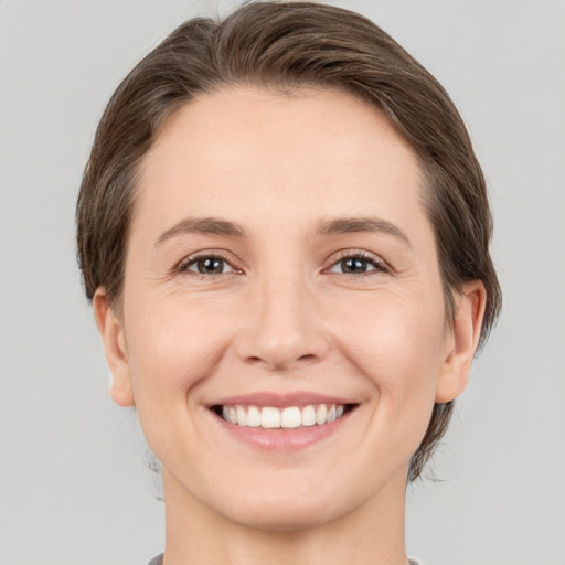 Joyful white young-adult female with short  brown hair and brown eyes