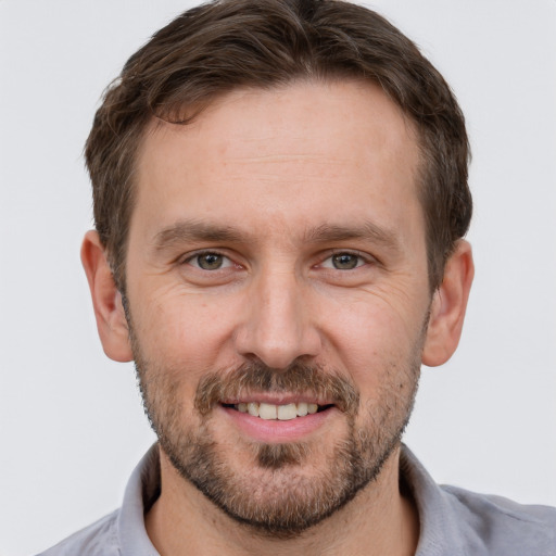 Joyful white adult male with short  brown hair and grey eyes