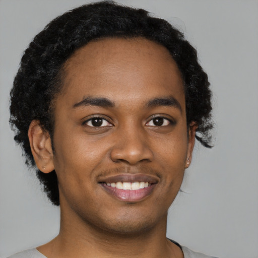 Joyful black young-adult male with short  brown hair and brown eyes