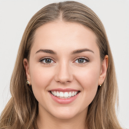 Joyful white young-adult female with long  brown hair and green eyes